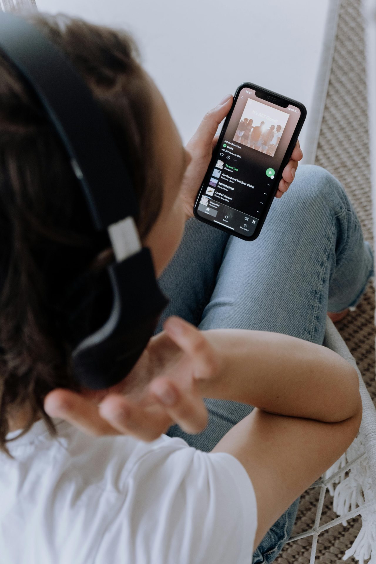 pexels-cottonbro-5077420 A shot from above someone show them wearing headphones and using Spotify on their mobile phone