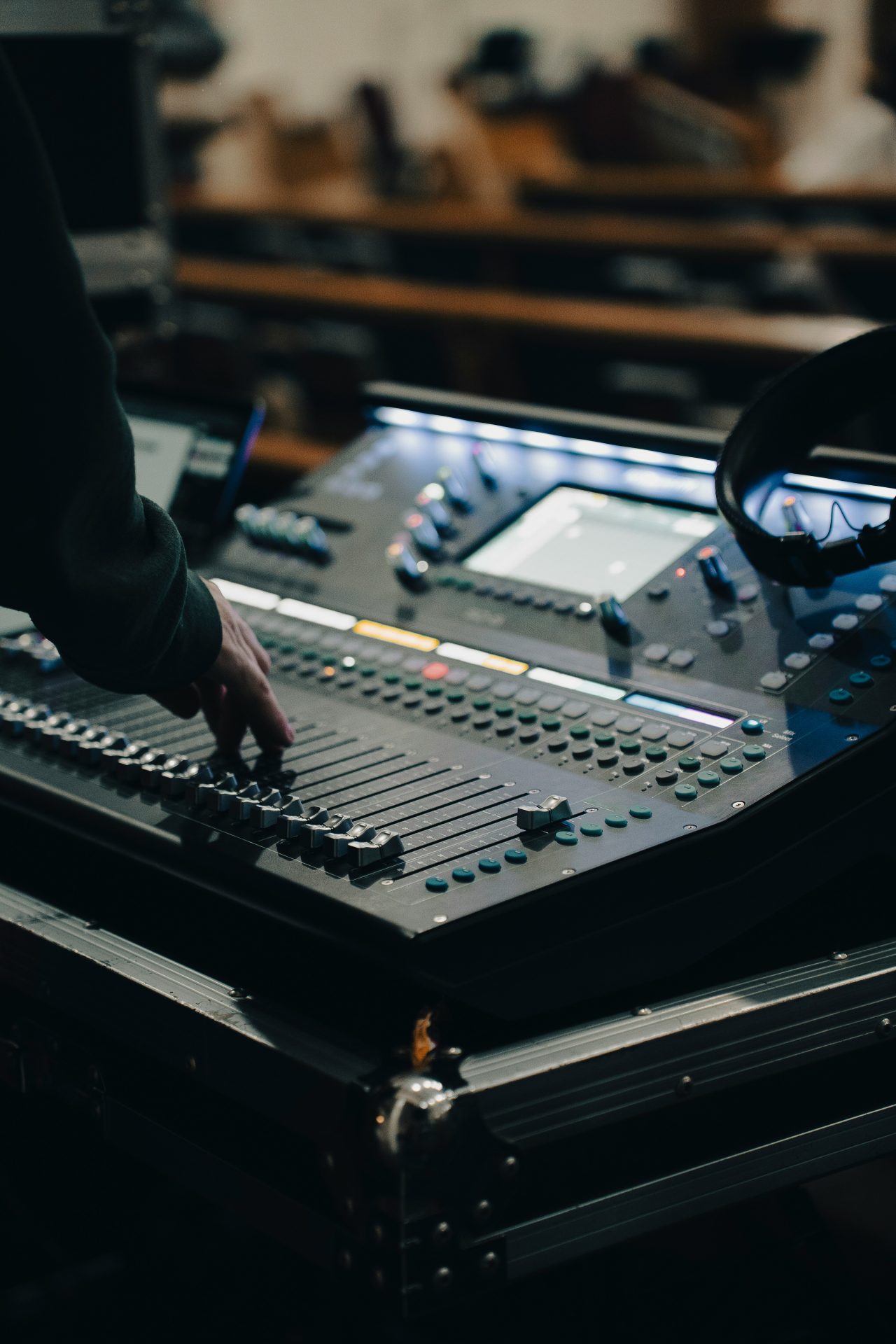 annie-m-wi6wNu6tlJA-unsplash A person's hand moving a fader on an audio mixing console