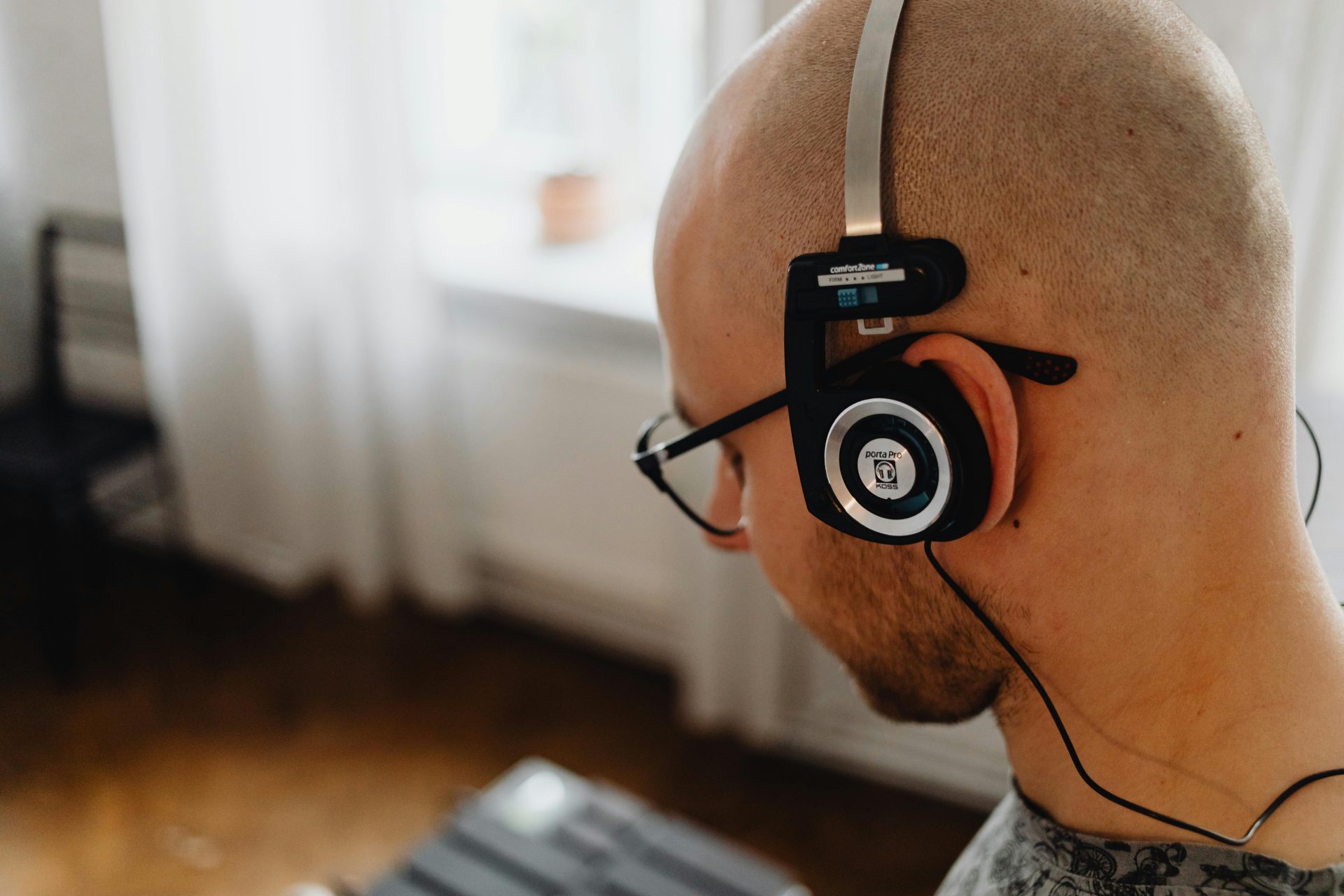 A man with glasses is wearing black headphones facing forward